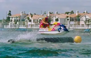 A man and a woman are riding a jet ski in the ocean.